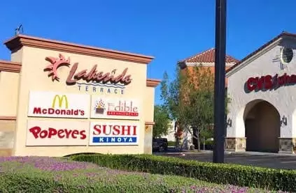 Shopping center sign with Lakeside Terrace logo, listing McDonald's, Edible Arrangements, Popeyes, and Sushi Kinoya; a CVS pharmacy is visible in the background.