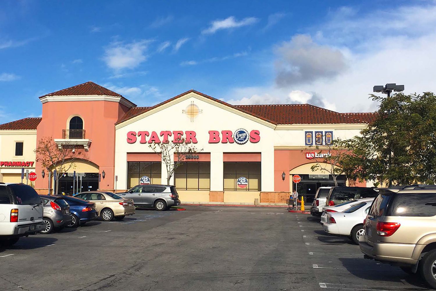 A Stater Bros grocery store with a parking lot in front. Several cars are parked, and the store entrance is visible under a clear sky.