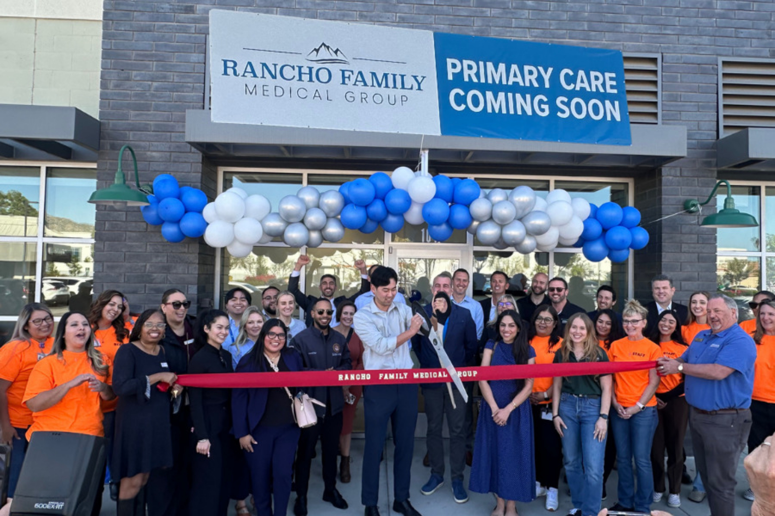 A vibrant group of healthcare professionals and community members celebrating the grand opening of Rancho Family Medical Group in Moreno Valley, highlighting expanded healthcare access.
